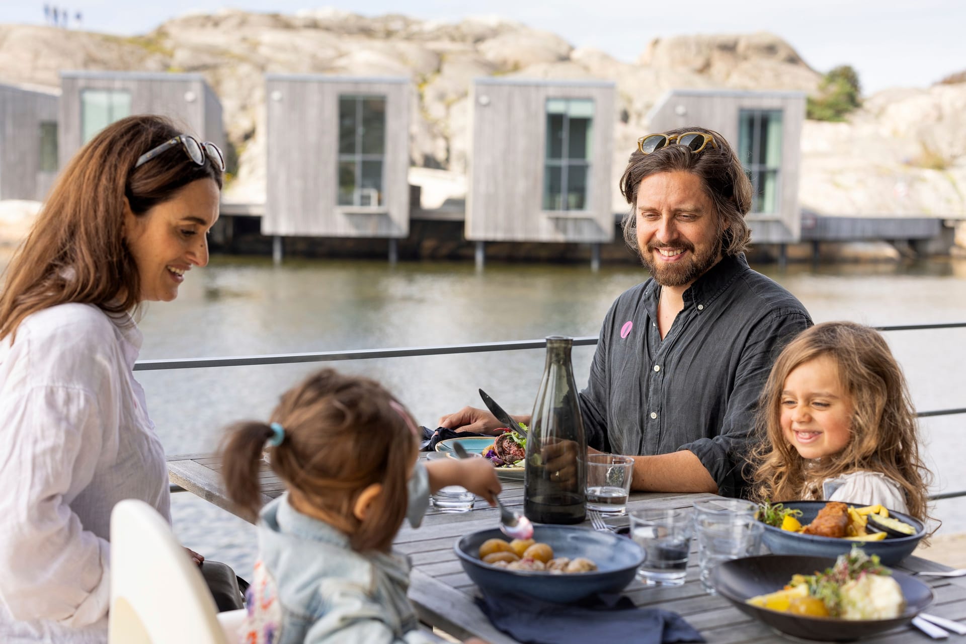 A family eating dinner next to the sea